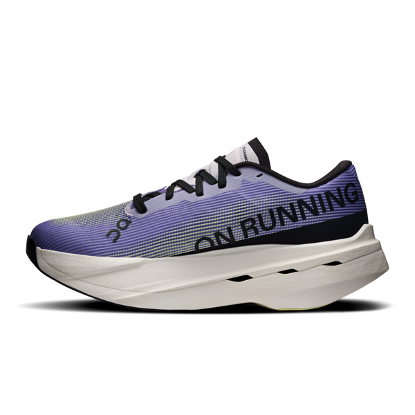 Et nærbillede fra siden af On Cloudboom Volt løbesko dame i Juniper/Limelight med sorte snørebånd og branding på siden. Den tykke, polstrede sål med sorte detaljer gør den ideel til tempotræning.