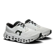 Et par On Cloudmonster 3 Dame løbesko i hvid/hvid med en tyk CloudTec-sål med udskæringer, sorte detaljer og snørebånd og ON RUNNING-tekst på siden, som vises på en almindelig hvid baggrund.