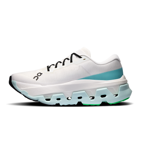 ON Cloudmonster 3 Hyper, Dame i farvekombinationen Ivory/Flurry, er en hvid sportssko med sorte snørebånd, en mellemsål i blå farveovergang og grønne detaljer på ydersålen. Den byder på maksimal dæmpning og karakteristiske udskæringer og vises her i profil mod en ensfarvet baggrund.