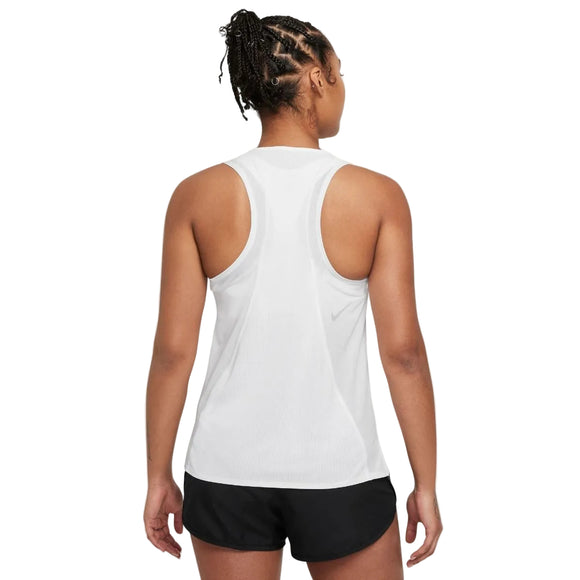 En kvinde med flettet hår ses bagfra iført en hvid Nike Dri-Fit Race Tank, Dame og sorte sportsshorts, stående mod en almindelig hvid baggrund.