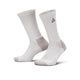Nike Ed Elvd Crew Socks (Unisex) i Photon Dust/College Grey har ribbede manchetter, grå hæle og tæer og et lille sort trekantet logo på læggen, som ses lodret på en hvid baggrund.