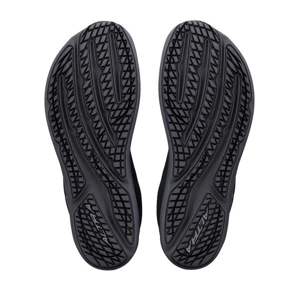 Billedet viser de sorte gummisåler på Altra Escalante 5, Dame, Black/Black/Black løbesko, der har et bølgelignende og geometrisk mønster, der sikrer godt greb, og som er designet til at give en naturlig løbeoplevelse for kvinder.