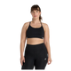 En kvinde med lys hud og brunt hår med pandehår står med ansigtet fremad iført New Balance Essential Yoga Bra, Dame, Black og højtaljede leggings i blødt, åndbart materiale. Hun har et neutralt udtryk mod en almindelig hvid baggrund.