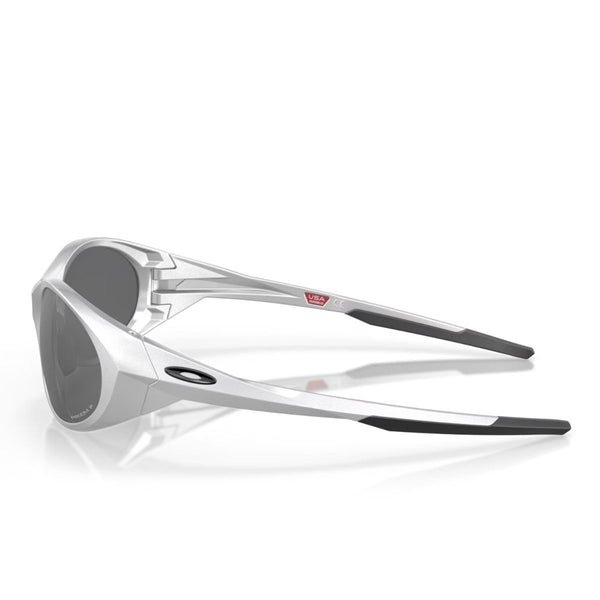 Sølvfarvede Oakley Eye Jacket Redux-solbriller med Prizm Black Polarized-linser vises på en hvid baggrund. Stellet har et kantet design, og Oakley-logoet er placeret på venstre stænger.