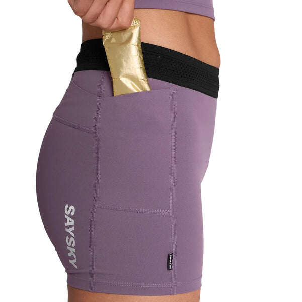 En person i Saysky W Flow+ Race Short Tights 4" Dame Purple lægger en guldpakke i baglommen på de ultralette træningstights.