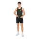 En mand står med ansigtet vendt fremad iført en grøn tanktop, Saysky Flow Shorts 5′’ Herre i sort, hvide sokker og hvide sportssko foran en ensfarvet hvid baggrund. Han holder en sort genstand med begge hænder ved taljen.