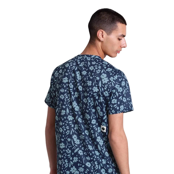 En person med kort mørkt hår, der vender ryggen til og kigger sig over skulderen, bærer Saysky Flower Combat T-Shirt, Herre, Blue Flower på en almindelig hvid baggrund.