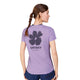 En kvinde med flettet hestehale bærer Saysky Flower Flow T-Shirt, Dame, Purple, med en stor sort blomstergrafik og SAYSKY COPENHAGEN-tekst på ryggen, sammen med marineblå shorts.