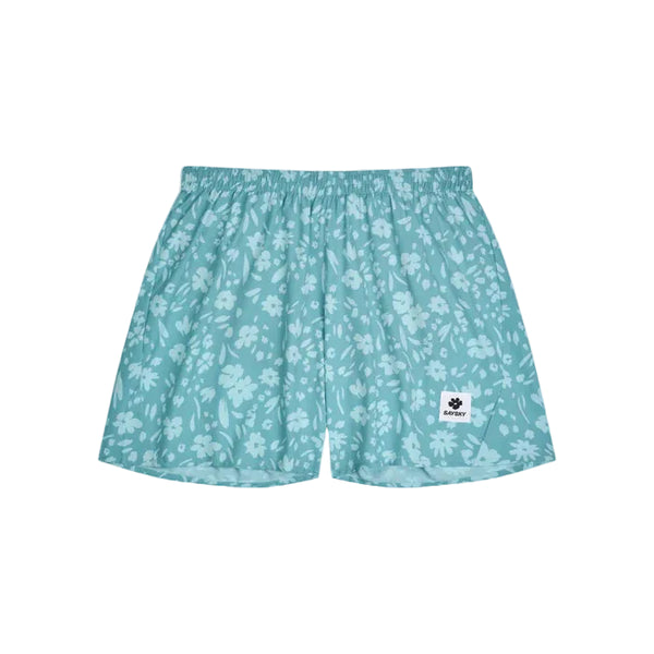 Saysky Flower Pace Shorts 5" i Light Blue Flower har et hvidt blomstermønster, elastisk linning og en lille rektangulær logopatch nederst på venstre ben. Disse herreshorts er vist lagt fladt på en hvid baggrund.