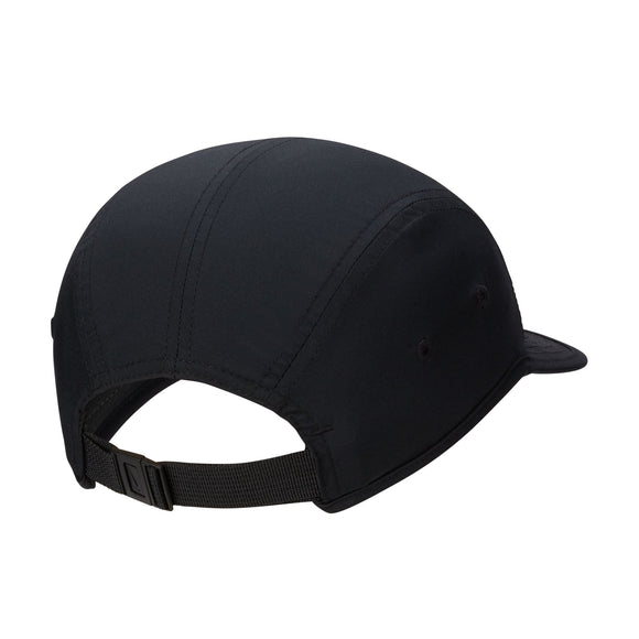 En sort unisex Fly Dri-Fit Unstructured Swoosh-kasket fra Nike ses set bagfra, hvor de synlige sømme, de to øjer i siderne og en justerbar rem med en plastikspænde fremhæves. Kasketten minder om klassiske løbekasket-modeller som Nike Dri-FIT Swoosh-kasketten, og skyggen er delvist synlig i forgrunden til højre.