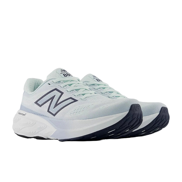 Et par New Balance FreshFoam 880 v15 Dame løbesko i Glint Blue/Nb Navy med hvide mellemsåler, sorte ydersåler og mørkeblå N-logoer på siderne, vist på en almindelig hvid baggrund.