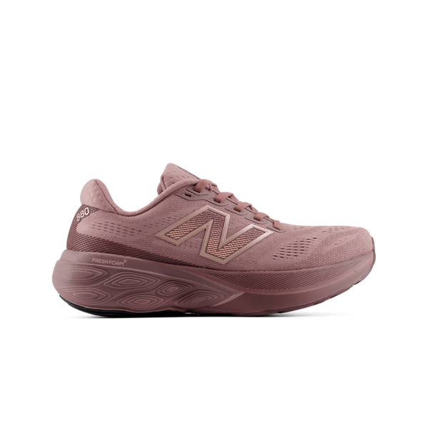 En enkelt lilla New Balance Freshfoam 880 V15 Dame Fast Track vises i profil på en hvid baggrund. Skoen har en overdel i mesh, snørelukning og en tyk, polstret sål med Fresh Foam-logoet tæt på hælen – et ideelt valg for dem, der søger komfort og støtte i deres dame-løbesko.