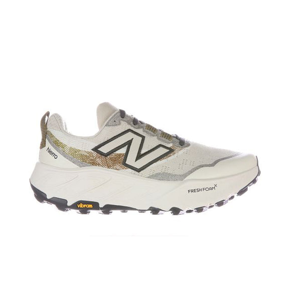 New Balance Freshfoam Hierro V9 Dame i angora har et hvidt og beige design, fedt sort N-logo, Fresh Foam X-sål, gult Vibram ydersålslogo og Hierro-branding - ideel som din go-to trail løbesko.