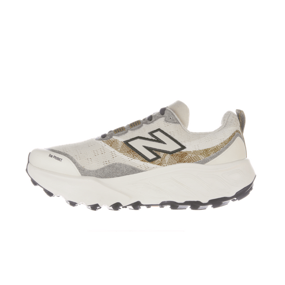 New Balance Freshfoam Hierro V9, Dame, Angora er en hvid og grå trailløbesko med en tyk sål, sort N-logo, guldfarvede detaljer og sort slidbane. Den vises på en almindelig hvid baggrund.