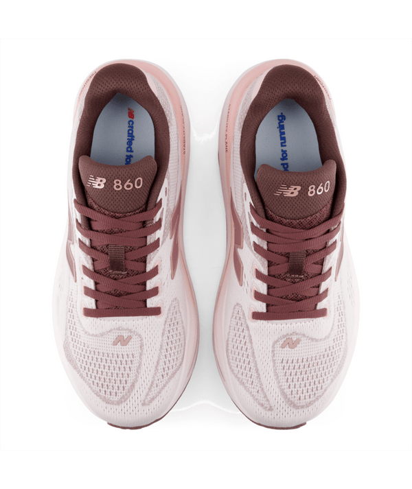 Et par New Balance Freshfoam X 860 V15 Dame i farven Pink Salt med rødbrune snørebånd, logo og detaljer, set ovenfra på en hvid baggrund.