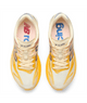 Oversigtsbillede af et par New Balance Fuelcell Supercomp Elite V6 Dame-løbesko i farvekombinationen Satsuma Orange x NYC Marathon, med gule og cremefarvede detaljer, et NB SCE Elite-logo på tungen og New Balance-logoet synligt på de lyserøde indlægssåler. Udstyret med Fuelcell Supercomp Elite-teknologi og en carbonplade for optimal ydeevne.