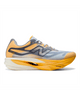 En satsuma-orange og grå løbesko med en tyk, buet hvid og orange sål, med New Balance-logoet og overdel i mesh. Denne Fuelcell Supercomp Elite V6 (Herre), der er designet til NYC Marathon, er en højtydende konkurrencesko til løbere, vist set fra siden på en ensfarvet hvid baggrund.
