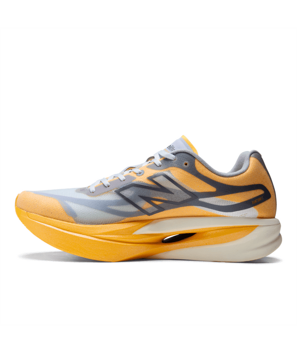 Et billede set fra siden af Fuelcell Supercomp Elite V6 fra New Balance (Herre, Satsuma Orange x NYC Marathon) viser en sportslig løbesko i levende orange og hvid med grå detaljer. Med en overdel i mesh, der sikrer god åndbarhed, en tyk, buet, stødabsorberende sål med carbonplade-teknologi og det ikoniske, stiliserede N-logo på siden er denne konkurrencesko udviklet til løbere, der søger ydeevne i eliteklassen.