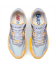 Oversigtsbillede af et par New Balance FuelCell Supercomp Elite V6, Herre, Satsuma Orange x NYC Marathon løbesko i lysegrå, gul og orange med hvide snørebånd. Den venstre indersål har et rødt logo, mens den højre indersål har blå tekst. Designet som konkurrencesko med carbonplade-konstruktion for optimal ydeevne. Mærkenavnet og modellen er trykt på tungen.