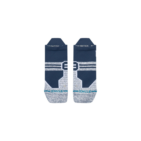 Et par Stance Fusion Grip Tab-løbesokker i unisex-farven navy, udstyret med skridsikre grippaneler for øget stabilitet, ligger fladt side om side på en hvid baggrund. Disse sportsokker har et farvespil i blå og grå med hvide striber og turkise detaljer ved tåen, suppleret med tekst og designdetaljer. Nyd komfort hele dagen med Stance FreshTek-teknologi.