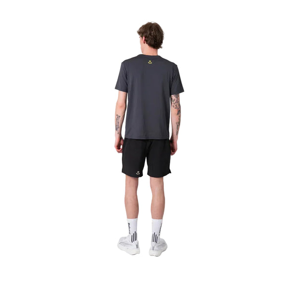 En person vender ansigtet væk fra kameraet i en Liiteguard Ground-Tech T-shirt, Herre, Ebony/Neon Yellow - ideel til løbetræning - med sorte shorts, hvide strømper og sko. Det lugtbekæmpende stof holder dig frisk mod en almindelig hvid baggrund.