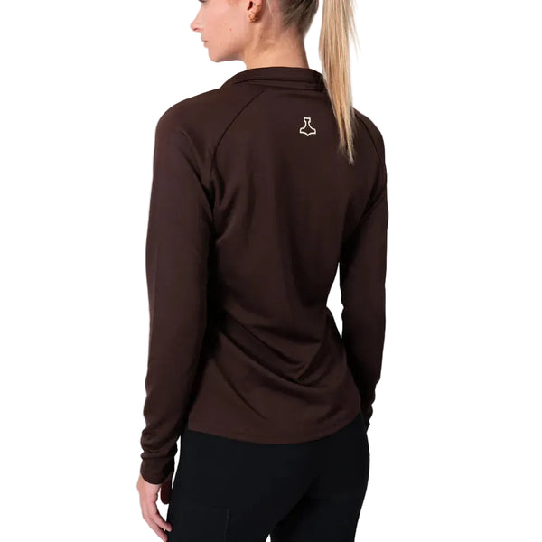 En kvinde med lyst hår i hestehale ses bagfra iført en Liiteguard Ground-Tech 1/4 Zip Dame i Coffee Bean med lille hvidt logo på øverste ryg samt sorte bukser.