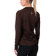 En kvinde med lyst hår i hestehale ses bagfra iført en Liiteguard Ground-Tech 1/4 Zip Dame i Coffee Bean med lille hvidt logo på øverste ryg samt sorte bukser.