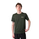 En person står på en hvid baggrund iført en Liiteguard Ground-Tech T-shirt, Herre, Army Green med sorte bukser. Den ene arm hviler på hoften og viser en underarmstatovering.