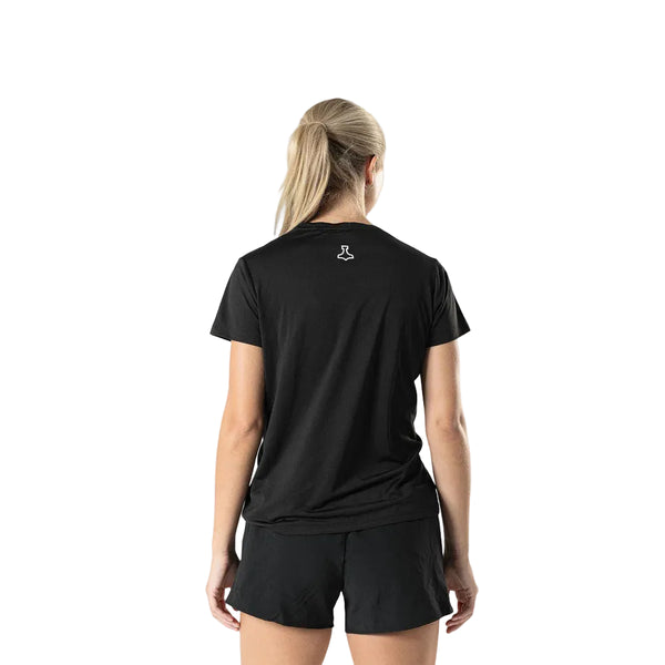 En kvinde med langt lyst hår i hestehale står med ansigtet vendt mod kameraet iført Liiteguard Ground-Tech T-shirt, Dame, Black - ideel til løbetræning - sammen med sorte shorts på en almindelig hvid baggrund.