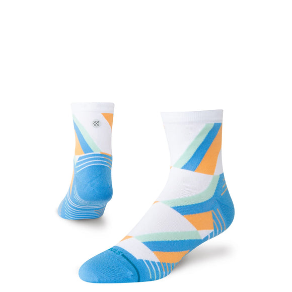 To blå Stance Gamma Ray UL Quarter unisex-strømper: en opretstående og fremadrettet, den anden viser hælen og siden. Begge har geometriske blå, orange og grønne mønstre med kontrastfarvede tæer.