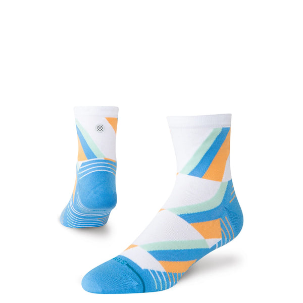 To blå Stance Gamma Ray UL Quarter unisex-strømper: en opretstående og fremadrettet, den anden viser hælen og siden. Begge har geometriske blå, orange og grønne mønstre med kontrastfarvede tæer.