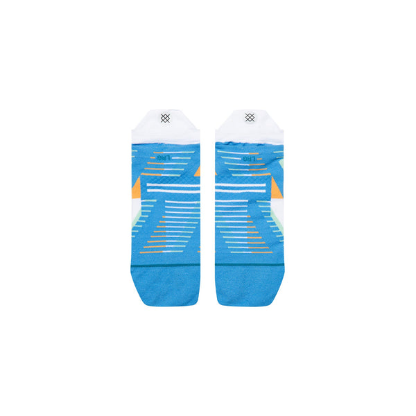 Et par Stance Gamma Ray UL Tab unisex-strømper i blå med orange, hvide og lyseblå geometriske mønstre og striber, Infiknit-forstærkninger, hvide hælkapper og et lille sort logo nær toppen. Lagt fladt på en hvid baggrund.
