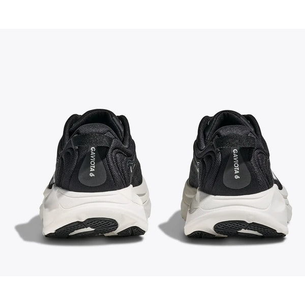 Et par Hoka Gaviota 6 Dame-sneakers i sort/hvid ses bagfra på en hvid baggrund med hvide såler og hælmærker, hvor der står "GAVIOTA 6" med hvid tekst.