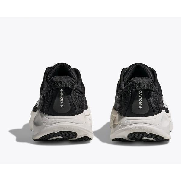 Et par Hoka Gaviota 6-sneakers til mænd i sort og hvid vises bagfra med tykke såler og et logo på hver hælkappe mod en almindelig hvid baggrund.