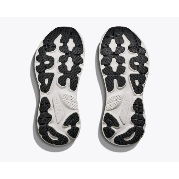 Et par Gaviota 6 såler fra Hoka i sort/hvid, vist nedefra med hvid bund og sorte gummimønstre. Mærkenavnet Hoka er præget på hver sål.