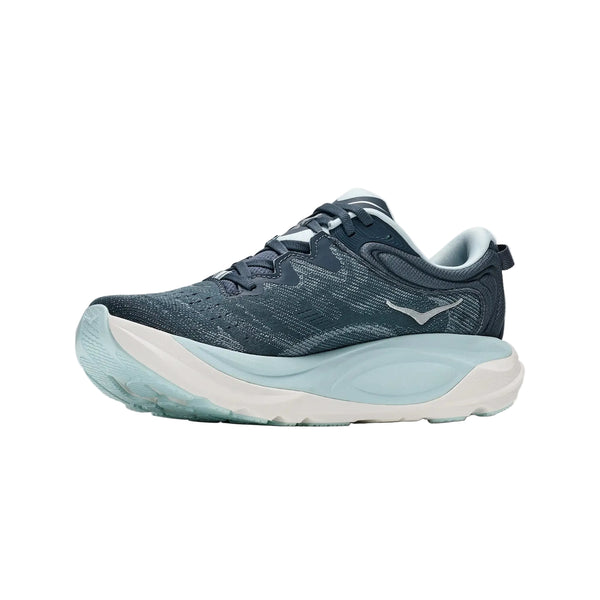 Hoka Gaviota 6-løbesko til kvinder i farven Faded Navy/Glimmering Blue har en tyk, lyseblå og hvid sål, en overdel i åndbart mesh og et diskret logo på siden, fotograferet på en ensfarvet hvid baggrund.