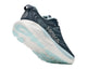 Her ses en Hoka Gaviota 6-løbesko til kvinder i farven Faded Navy/Glimmering Blue set bagfra, med en tyk hvid sål med lyseblå detaljer og Hoka-logoet – ideel som en stabil løbesko.