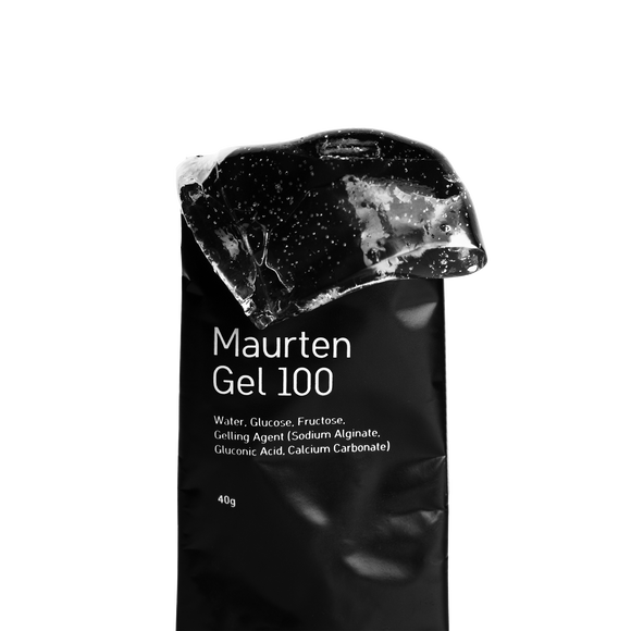 En Maurten Gel 100, Neutral-pakke står oprejst med sine ingredienser udstillet. Ovenover ses en blank portion af den halvfaste energigel på en hvid baggrund.