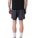 En person vender sig væk fra kameraet iført en sort skjorte og Liiteguard Glu-Tech Running 2In1 Shorts i Ebony. De har synlige tatoveringer på armen, høje hvide sokker og hvide sneakers på en almindelig hvid baggrund.
