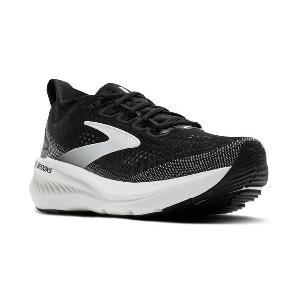 Brooks Glycerin GTS 23, dame, i sort/grå/hvid er en løbesko i premium-klassen til mængdetræning, der har hvide og grå detaljer på en elegant sort overdel. Med sin tykke hvide sål og den strukturerede sorte ydersål fremvises denne løbesko til kvinder på en ensfarvet hvid baggrund.
