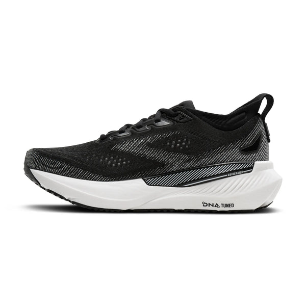 Et sidebillede af Brooks Glycerin GTS 23-løbeskoen til kvinder i farvekombinationen sort/grå/hvid vises på en ensfarvet hvid baggrund. Denne sportslige løbesko har en åndbar overdel i mesh med sorte og grå detaljer, suppleret af en tyk hvid sål med teksten »DNA LOFT v3« og »DNA TUNED«. Den er designet til optimal komfort og støtte og er perfekt som en løbesko til kvinder til enhver løbetur.