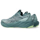 Et par ASICS Gt-2000 15 løbesko til herre i farven Foggy Teal/Illuminate Yellow med tykke, stødabsorberende såler. Disse stabilitetssko har sorte detaljer, synlige sømme og det karakteristiske ASICS-logo på siden. Ydersålerne har en lidt lysere grøn nuance.