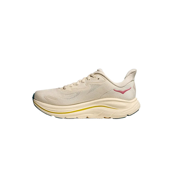 Hoka Clifton 10 damesko i Birch/Alabaster har en støddæmpende, tyk sål med gul stribe, mesh-overdel, pink logo og sort ydersål. Den lette løbesko vises fra siden på hvid baggrund.