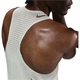 Nærbillede af den øverste del af ryggen og skulderen på en person iført Nike M Nk Dfadv Aeroswift Jakob Singlet til mænd i Sail/Metallic Gold med et lille Nike-logo ved halsen og sved, der afspejler intens træning.