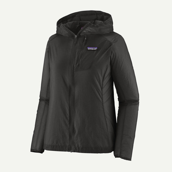 Patagonia Houdini Jacket, Dame, Black w/Black er en letvægtsjakke til kvinder fremstillet af genbrugsnylon med hætte, gennemgående lynlås foran, brystlomme og et rektangulært logo på venstre bryst. Vist på en almindelig hvid baggrund.