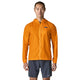 En person står med ansigtet vendt fremad foran en ensfarvet hvid baggrund og har en Patagonia Houdini-jakke (herre) i farven Autumn Orange på samt grå shorts.