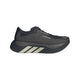 Adidas Hyperboost Edge i farvekombinationen Chacoa/Ntgrey/Alumin x Hermanos Koumori er en sort løbesko til kvinder med en tyk sål, diskret logo på siden og tre diagonale sølvstriber nær hælen. Denne komfortfokuserede løbesko til landevejsløb, der vises på en hvid baggrund, kombinerer stilfuldt design med enestående komfort til din løbetur.