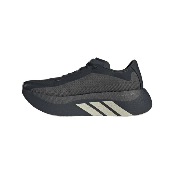 Et sidebillede af Adidas Hyperboost Edge Dame-løbeskoen i farvekombinationen Chacoa/Ntgrey/Alumin x Hermanos Koumori – en sort sportsløbesko med en tyk sål, grå detaljer og tre hvide diagonale striber på mellemsålen – fotograferet på en hvid baggrund. Denne komfortfokuserede landevejsløbesko fra Adidas forener moderne design med enestående ydeevne.
