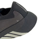 Nærbillede af hælen og siden på den mørke Hyperboost Edge herreløbesko, med Adidas-logoet på bagflappen, geometriske mønstre langs sidepanelet og kontrastfulde, lyse striber på mellemsålen – hvilket fremhæver et komfortfokuseret design til landevejsløb i samarbejde med Hermanos Koumori.