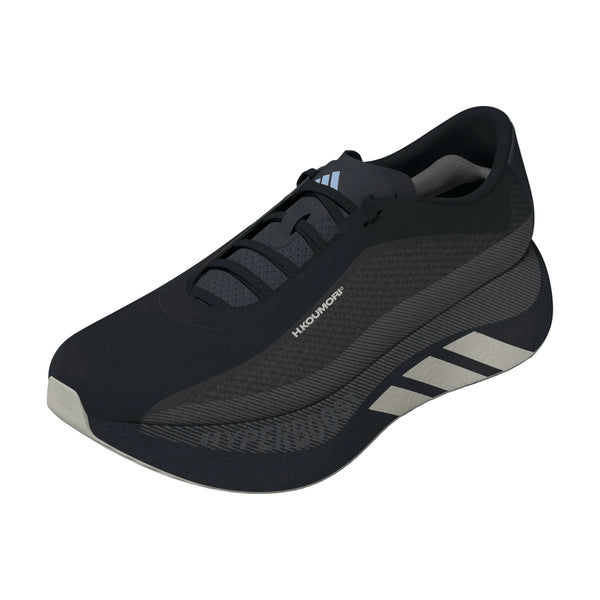 En sort Adidas Hyperboost Edge-løbesko til mænd i farvekombinationen Chacoa/Ntgrey/Alumin x Hermanos Koumori med grå detaljer, en tyk, stødabsorberende sål og teksten »HUGOMOON« på siden. Denne komfortfokuserede landevejs-løbesko til mænd har et moderne, strømlinet design og vises på en hvid baggrund.
